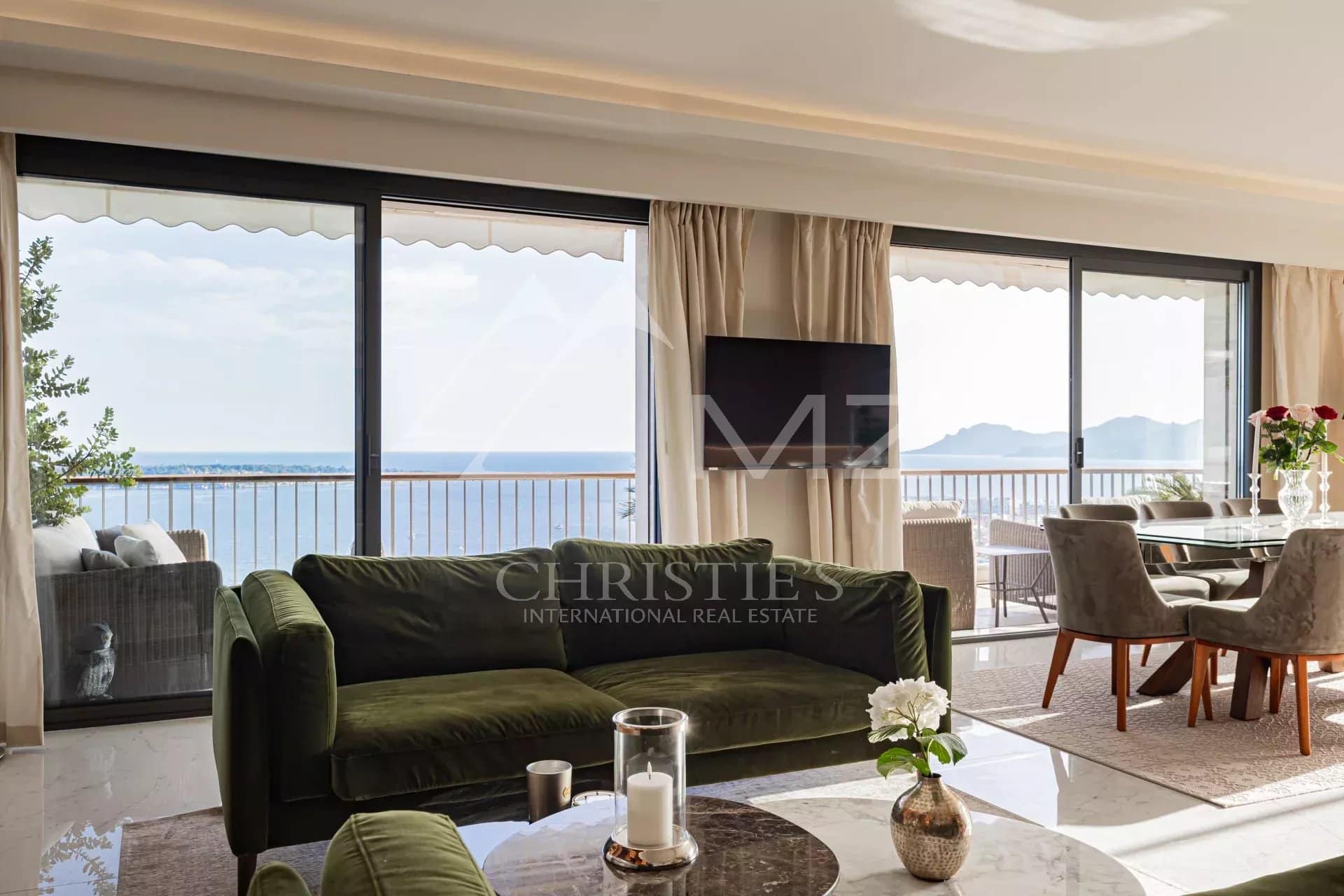 Interior of a penthouse in Cannes with sea view, bright living room and modern furniture.