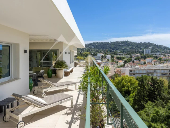 Rooftop terrace of a villa in Cannes with views of the hills and the sea.