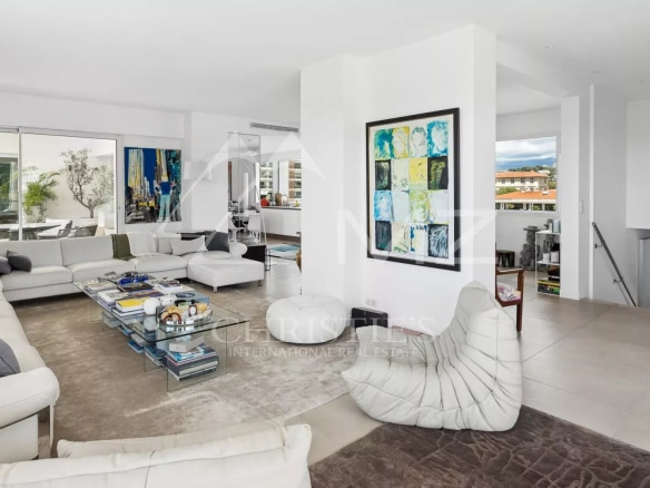 Interior of a rooftop villa in Cannes, bright living room with modern furniture and views of the hills.
