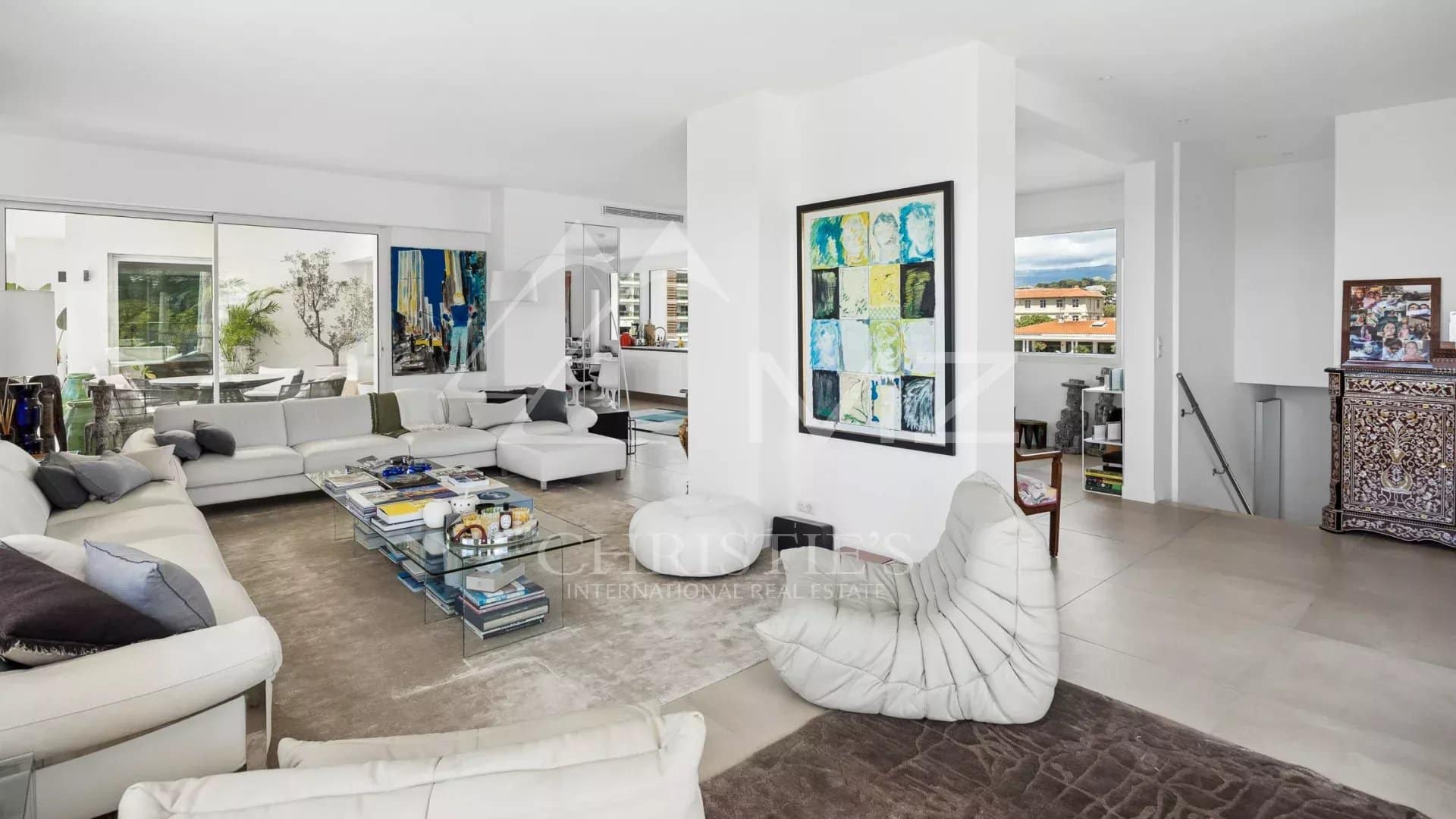 Interior of a rooftop villa in Cannes, bright living room with modern furniture and views of the hills.