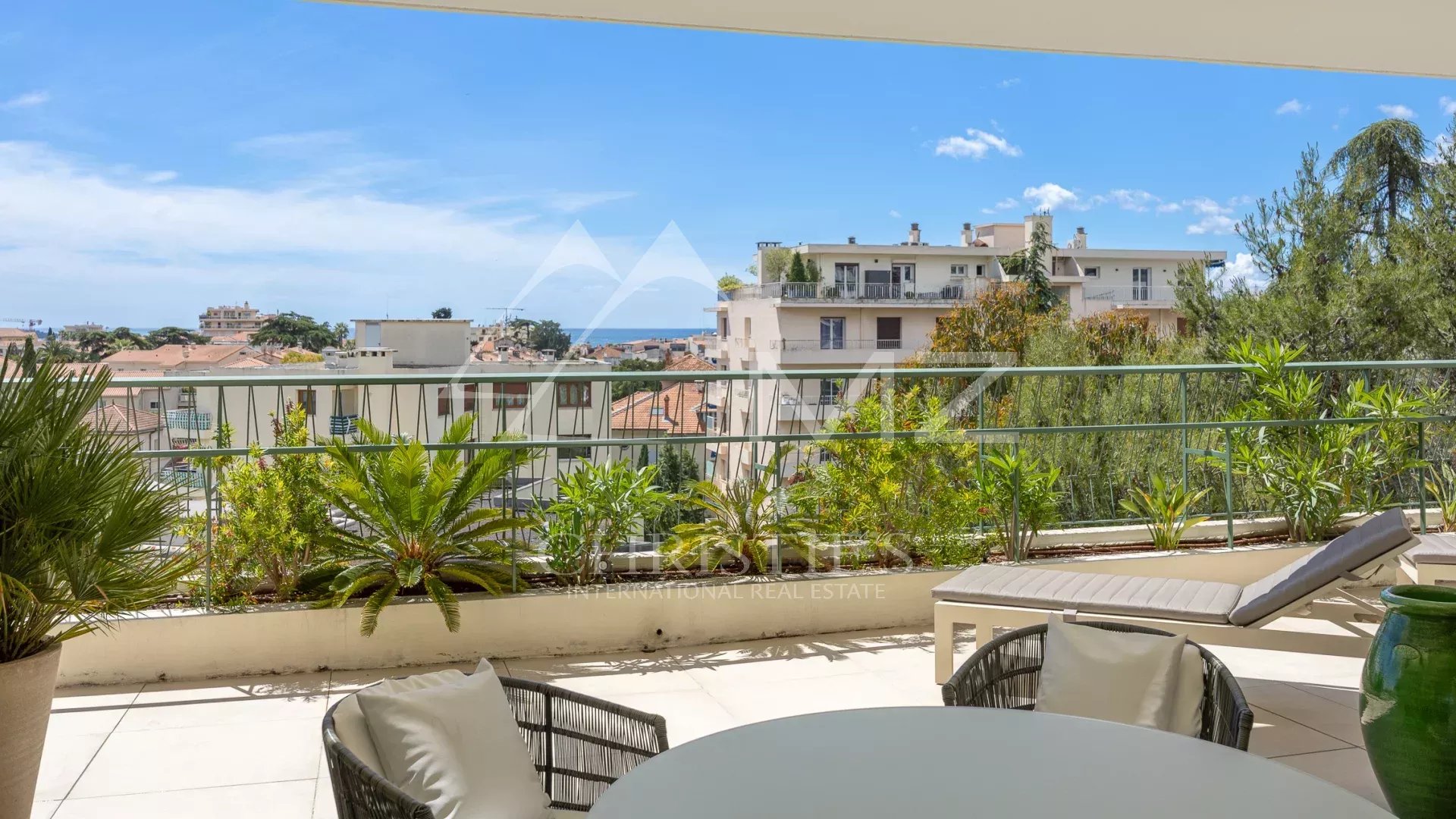 Terrace of a villa in Cannes with panoramic views of the hills and a glimpse of the sea.