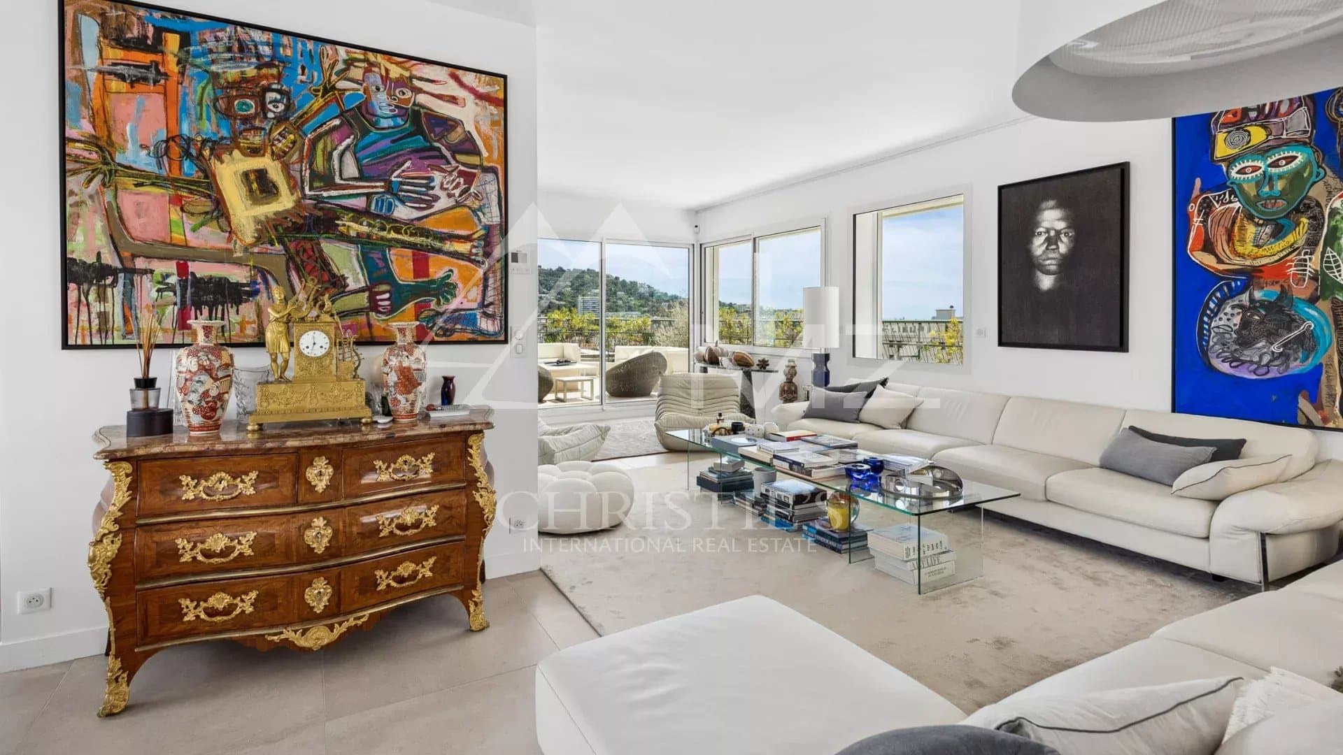 Living room of a rooftop villa in Cannes with modern decor and views of the hills.