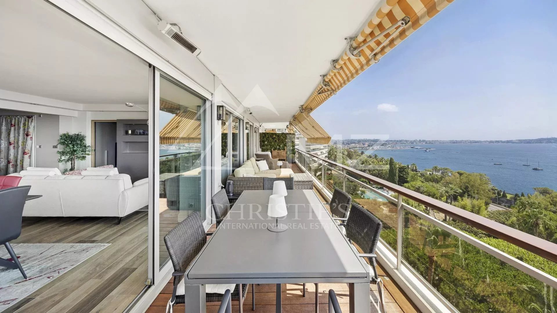 Terrace of a top-floor apartment with sea views in Cannes, outdoor furniture and seascape.