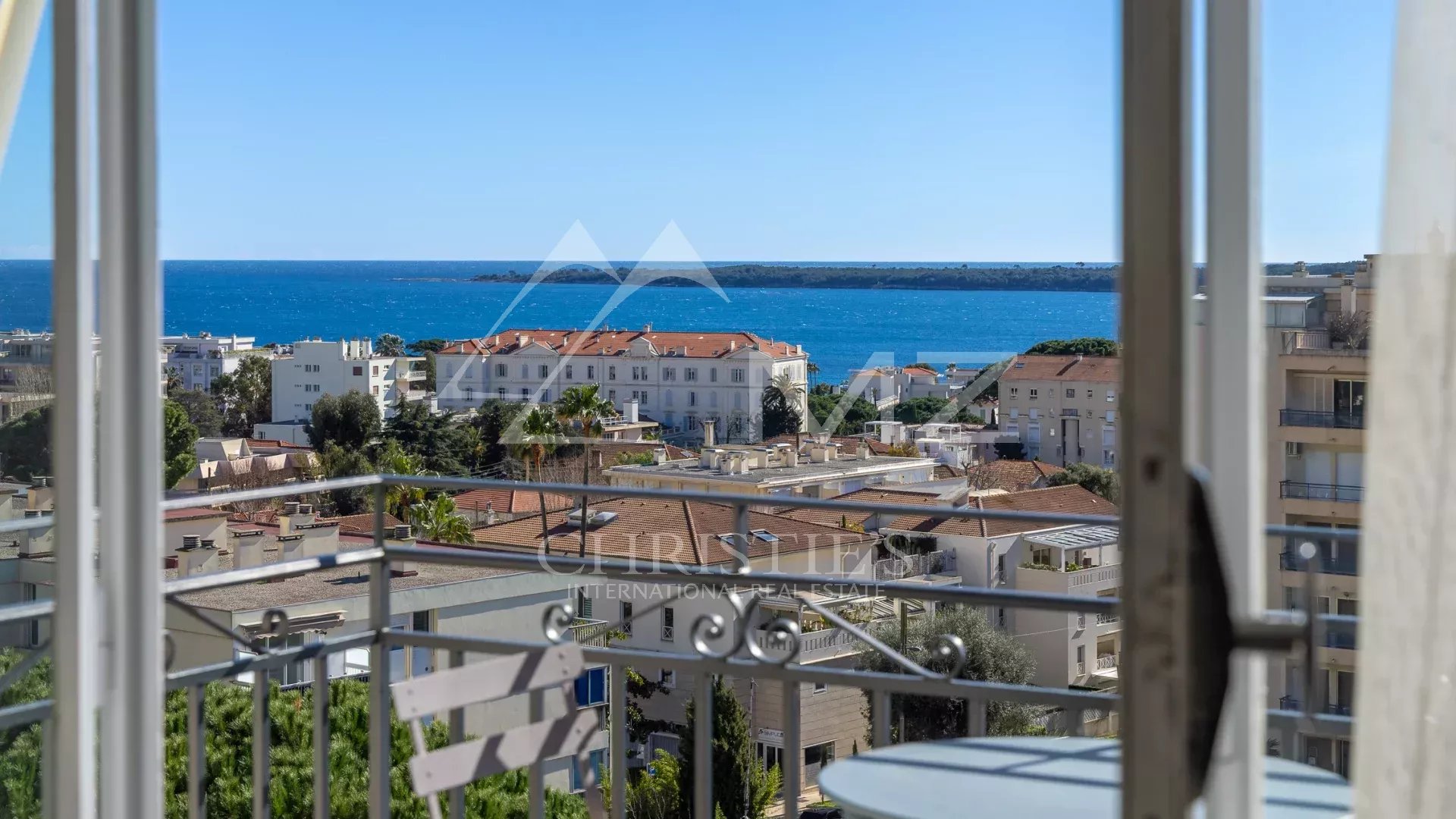 Vue mer depuis un appartement à Cannes Vue mer depuis un appartement au dernier étage à Cannes, avec des bâtiments et la mer en arrière-plan.