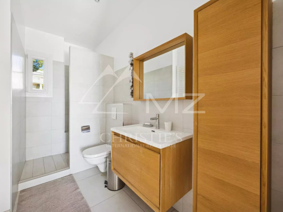 Salle de bains moderne avec douche et meuble en bois.