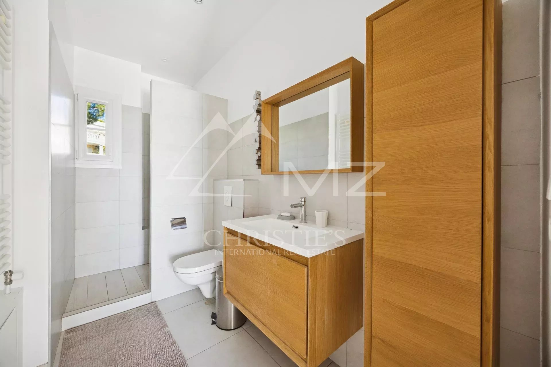 Salle de bains d’un appartement à Cannes Salle de bains moderne avec douche et meuble en bois.