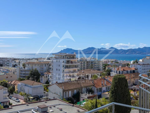 Vue panoramique sur la mer et les montagnes depuis un dernier étage à Cannes.