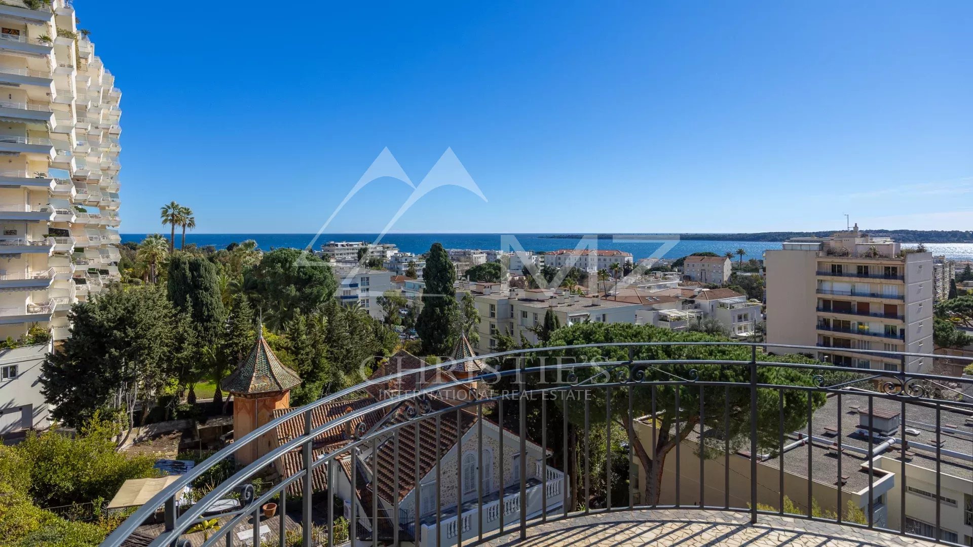 Vue mer depuis un appartement à Cannes Vue mer depuis le dernier étage d'un appartement à Cannes, entouré de verdure.