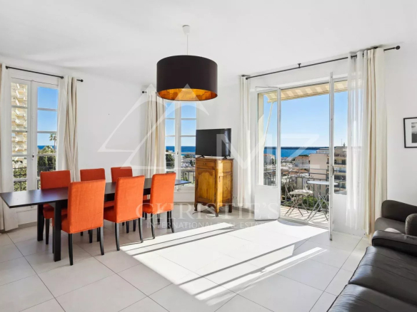 Intérieur d'un appartement lumineux avec vue sur la mer à Cannes, salle à manger et salon.