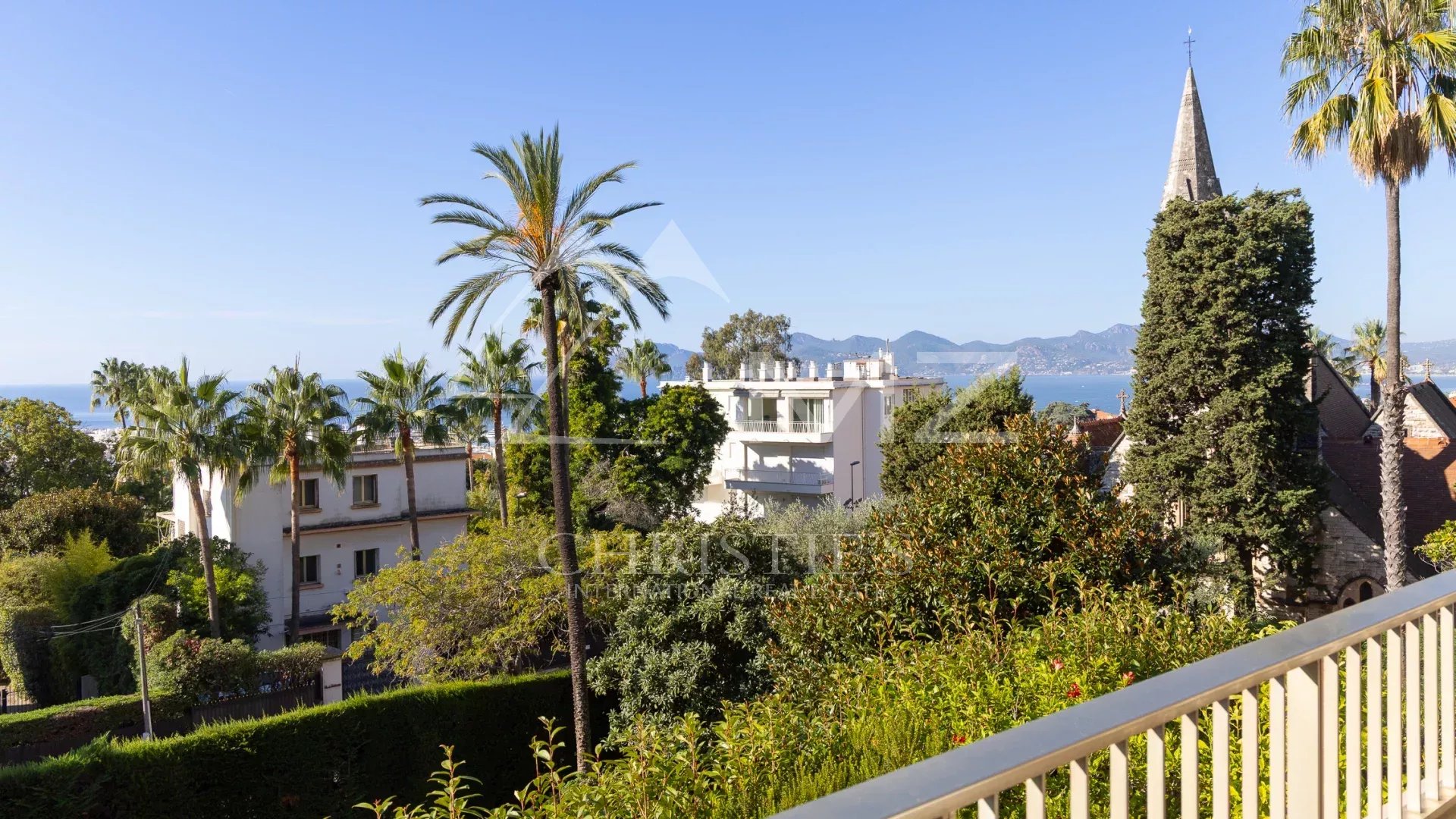 Vue dégagée sur la mer et l'église Saint-Georges depuis une terrasse d'angle à Cannes.