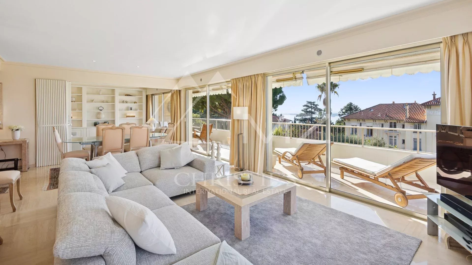 Salon lumineux d'un appartement d'angle à Cannes avec vue sur la mer et terrasse.