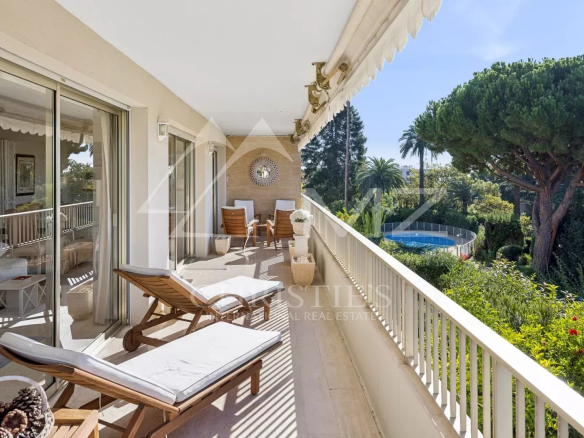 Terrasse d'angle d'un appartement à Cannes avec vue sur la mer et jardin.