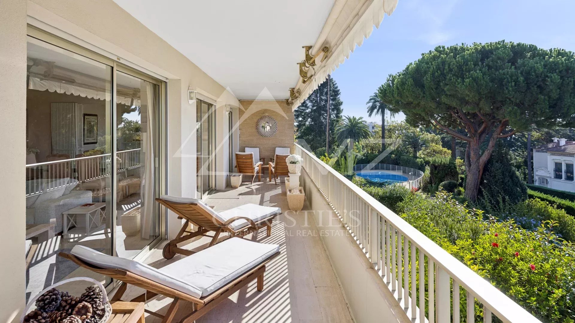 Terrasse d'angle d'un appartement à Cannes avec vue sur la mer et jardin.