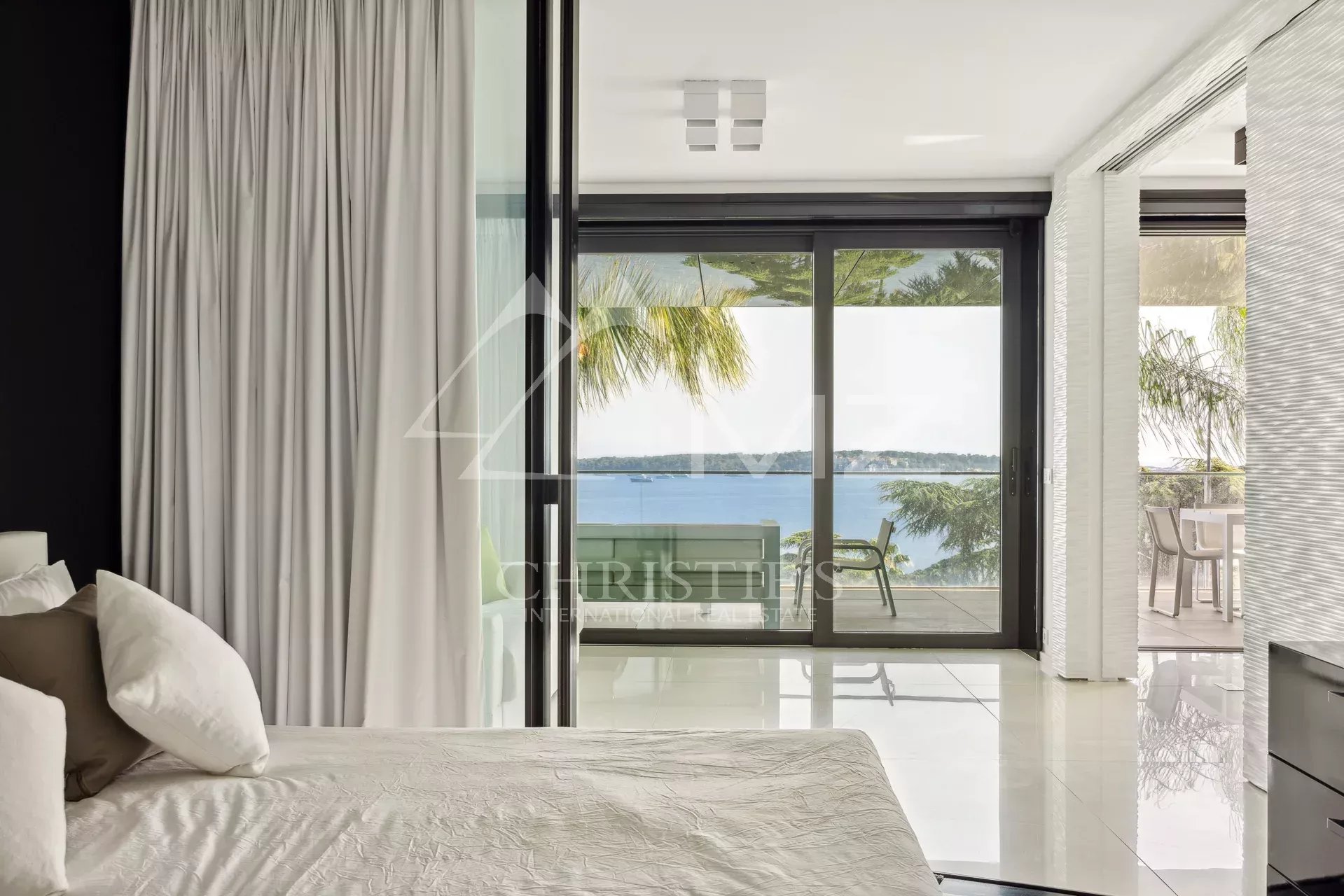 Chambre d'un appartement de luxe à Cannes avec vue sur la mer depuis la terrasse.