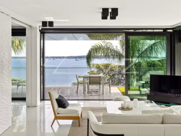 Salon moderne avec vue sur la mer à Cannes, terrasse spacieuse en arrière-plan.
