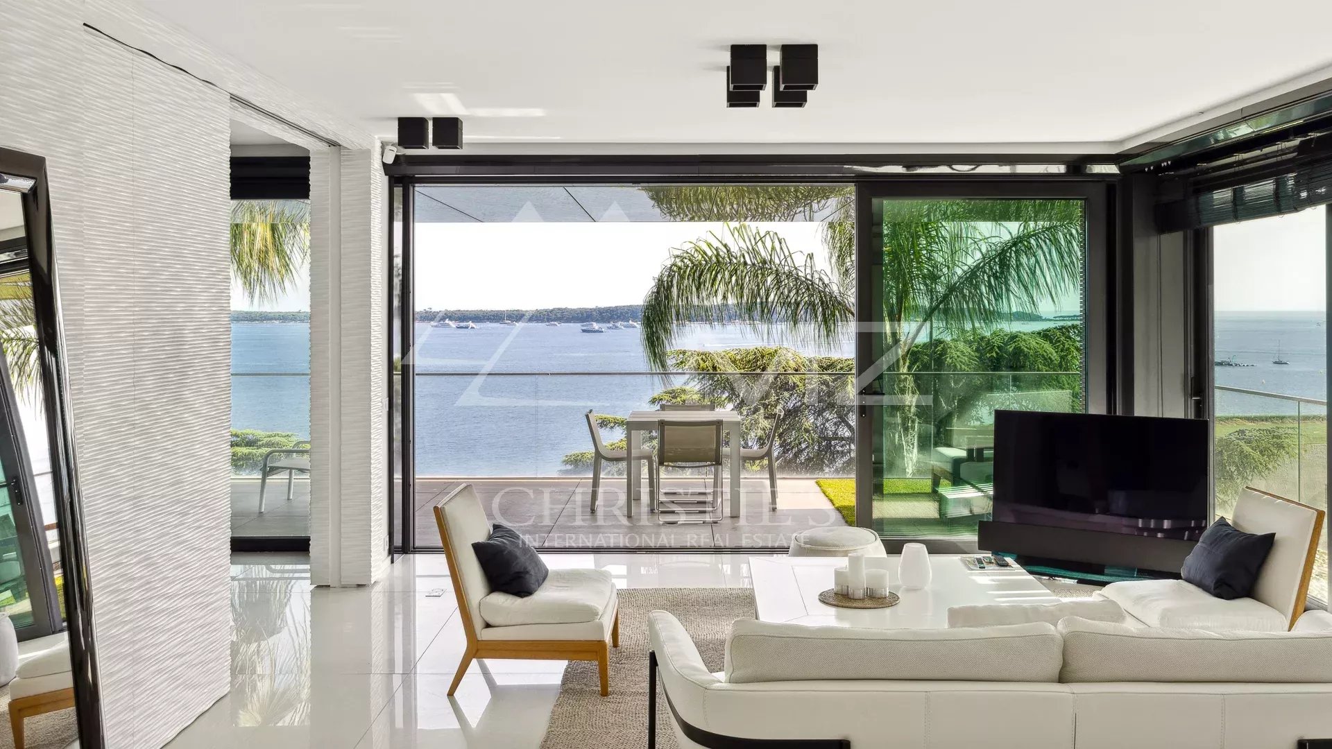 Salon moderne avec vue sur la mer à Cannes, terrasse spacieuse en arrière-plan.