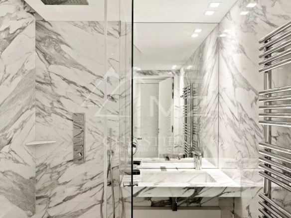 Salle de bain moderne avec murs en marbre et douche en verre
