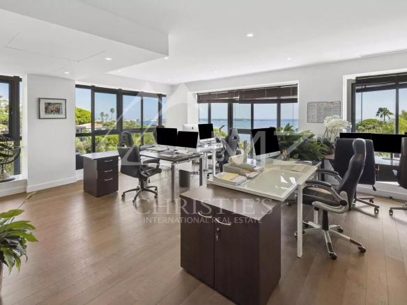 Modern office with sea view in Cannes, large windows and contemporary furniture.