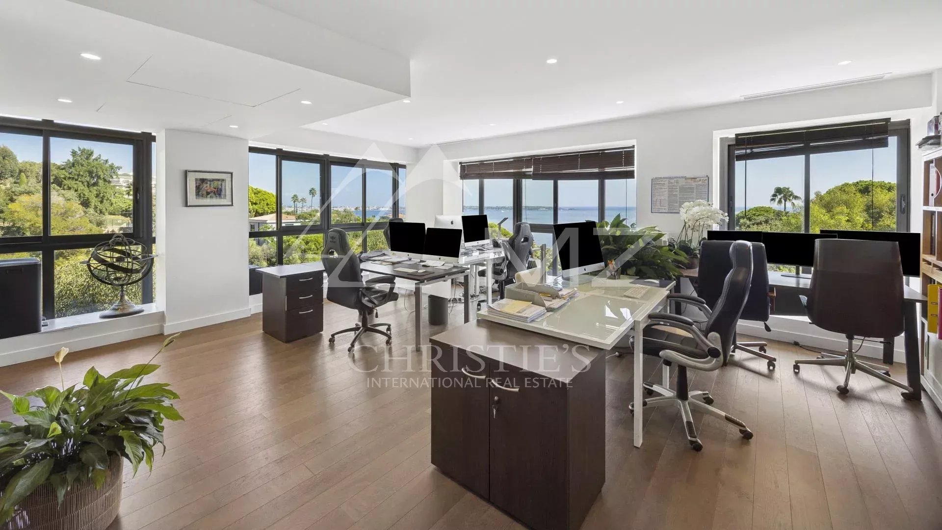 Modern office with sea view in Cannes, large windows and contemporary furniture.