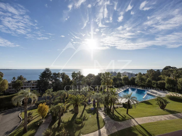 Vue panoramique sur la mer depuis une résidence avec piscine et parc à Cannes.