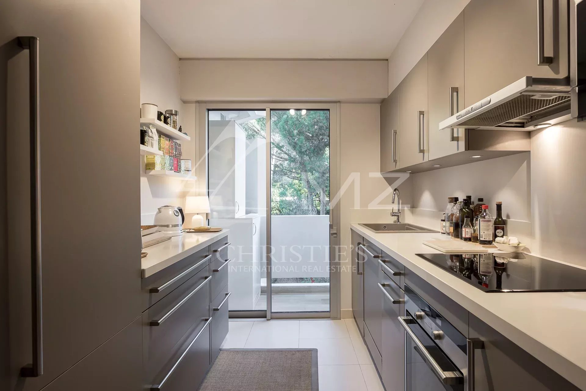 Cuisine d’un appartement à Cannes Cuisine moderne d'un appartement de prestige à Cannes avec accès à un balcon.