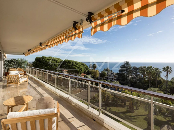 Terrasse d'un appartement à Cannes avec vue panoramique sur la mer et le jardin.
