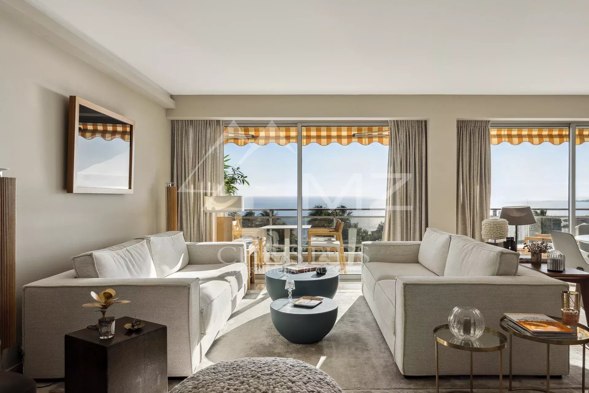 Salon d’un appartement de prestige à Cannes Salon lumineux d'un appartement de prestige avec vue mer à Cannes, mobilier moderne et décoration élégante.