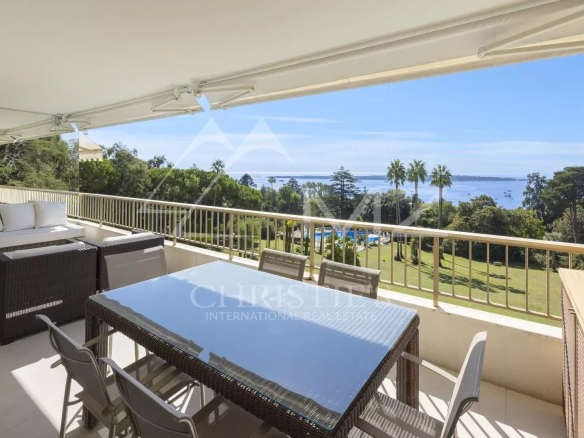 Terrasse d'un appartement à Cannes avec vue sur la mer et mobilier extérieur.
