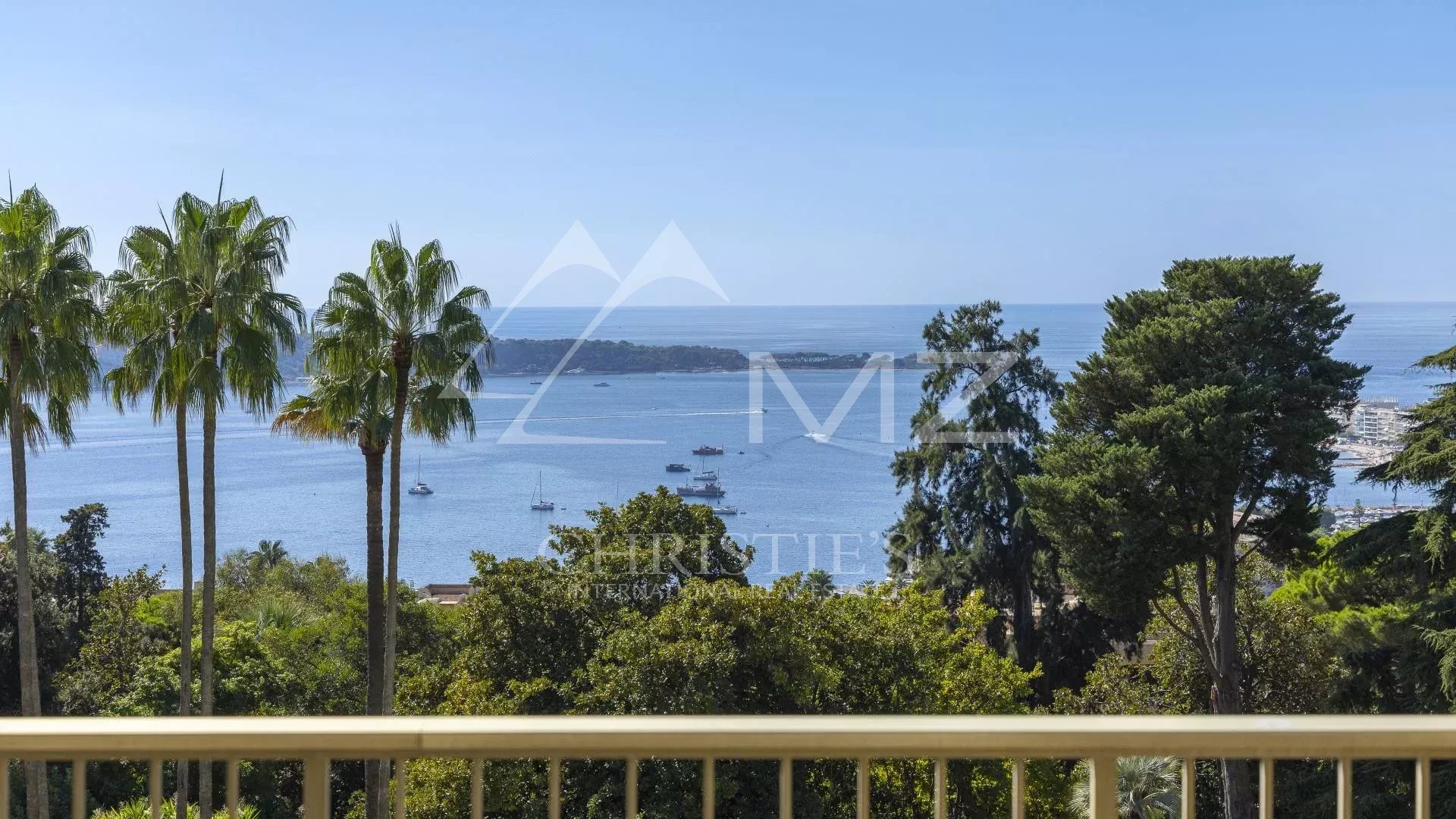 Vue panoramique depuis un appartement à Cannes Vue sur la mer depuis un balcon avec des palmiers et des arbres, quartier Californie, Cannes.