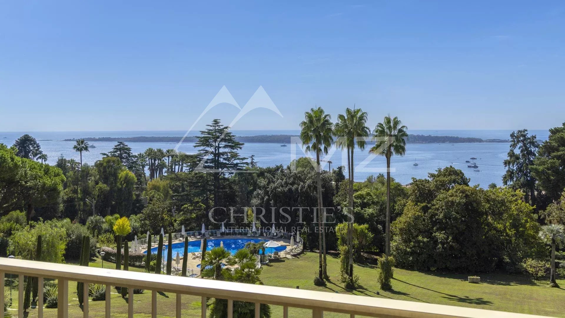 Vue depuis un appartement à Cannes Vue panoramique depuis un balcon sur la mer et un parc avec piscine à Cannes.