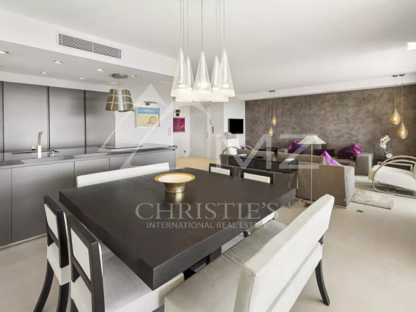 Intérieur d'un appartement contemporain à Cannes, avec salle à manger, cuisine moderne et salon lumineux.