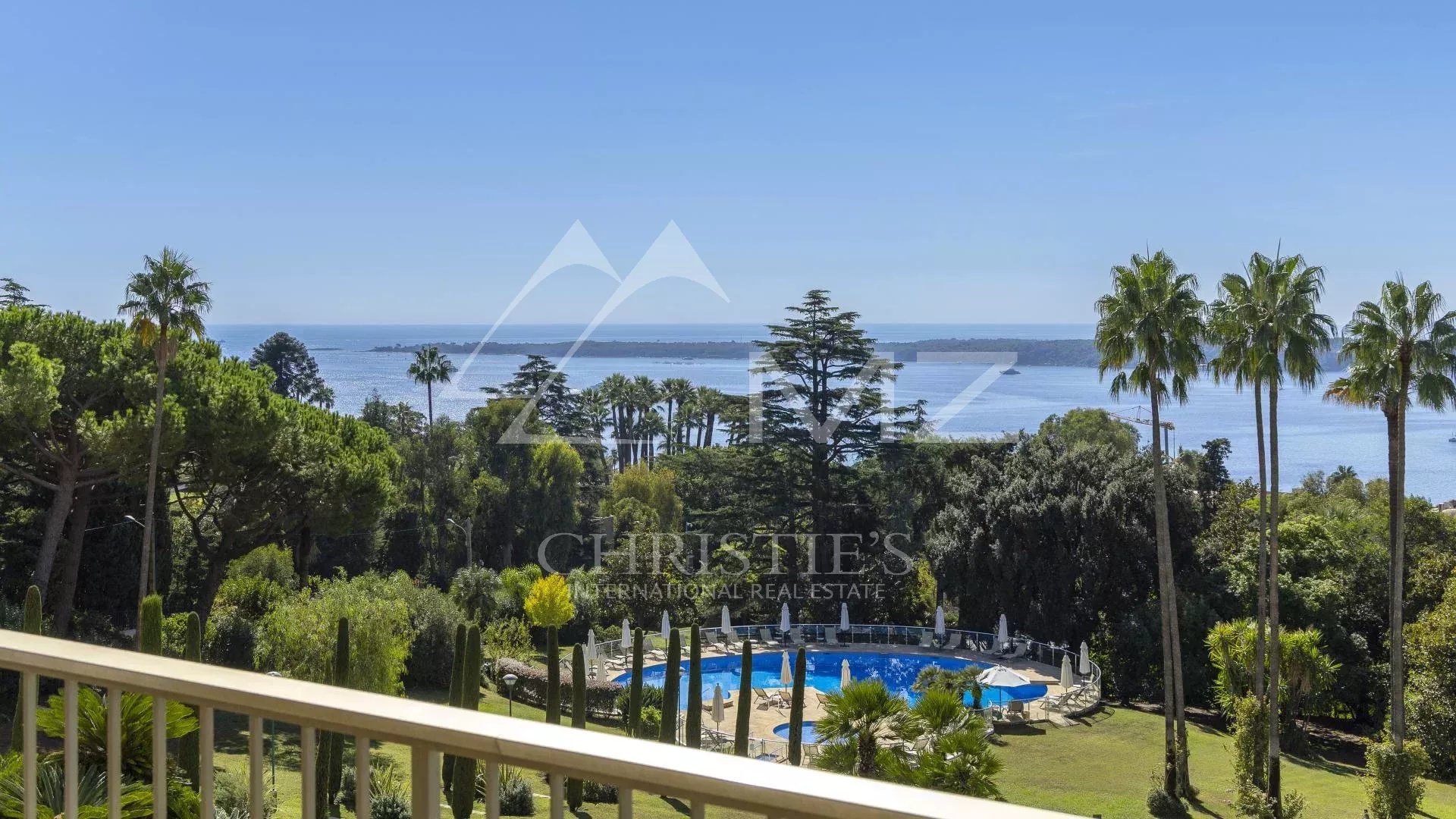 Vue depuis un appartement à Cannes Vue panoramique depuis un appartement à Cannes, avec piscine et parc verdoyant en premier plan.