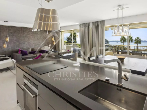Appartement contemporain à Cannes avec vue sur la mer, séjour lumineux et cuisine moderne.
