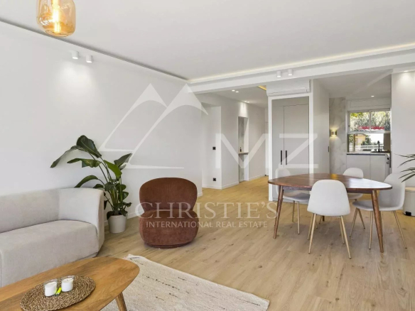Interior of a renovated apartment in Cannes, with a bright living room and kitchen area.