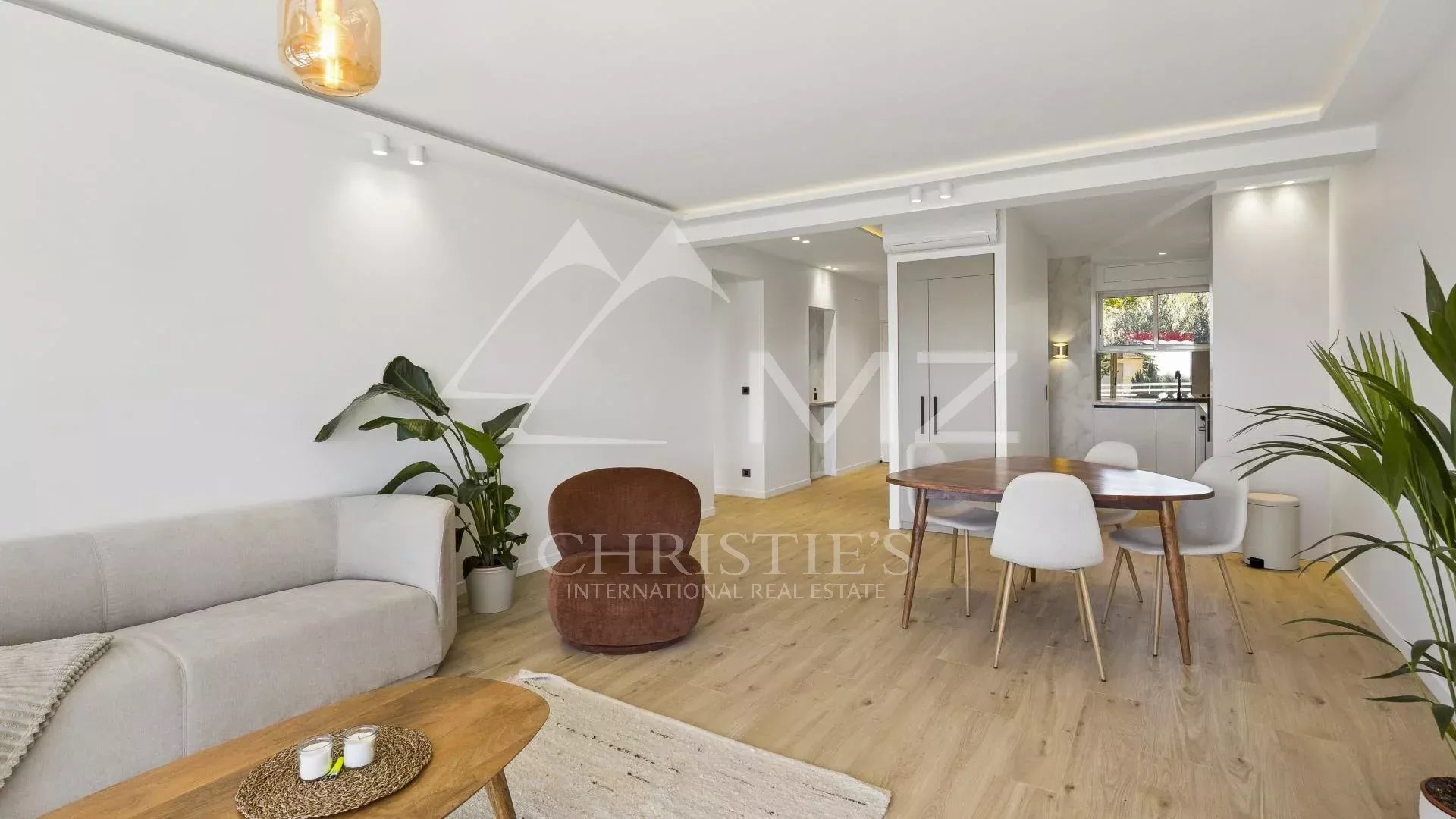 Interior of a renovated apartment in Cannes, with a bright living room and kitchen area.