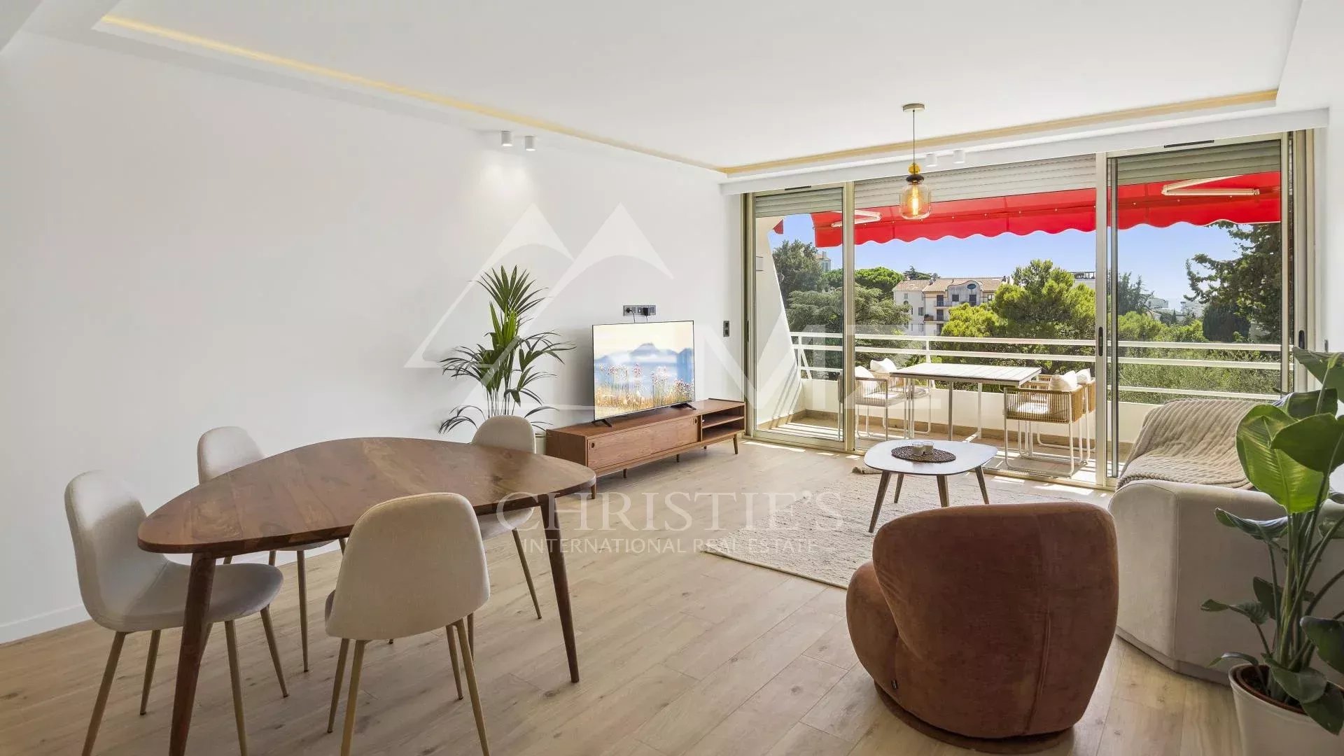 Interior of a renovated apartment in Cannes with a bright living room and a terrace offering an unobstructed view.