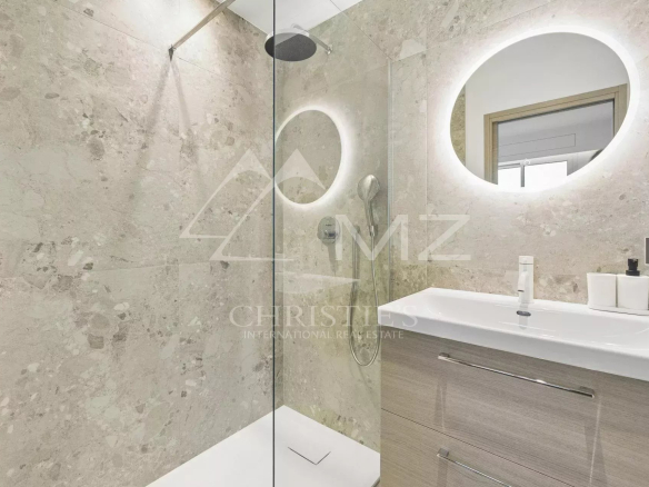 Modern bathroom with glass shower and wooden vanity unit.