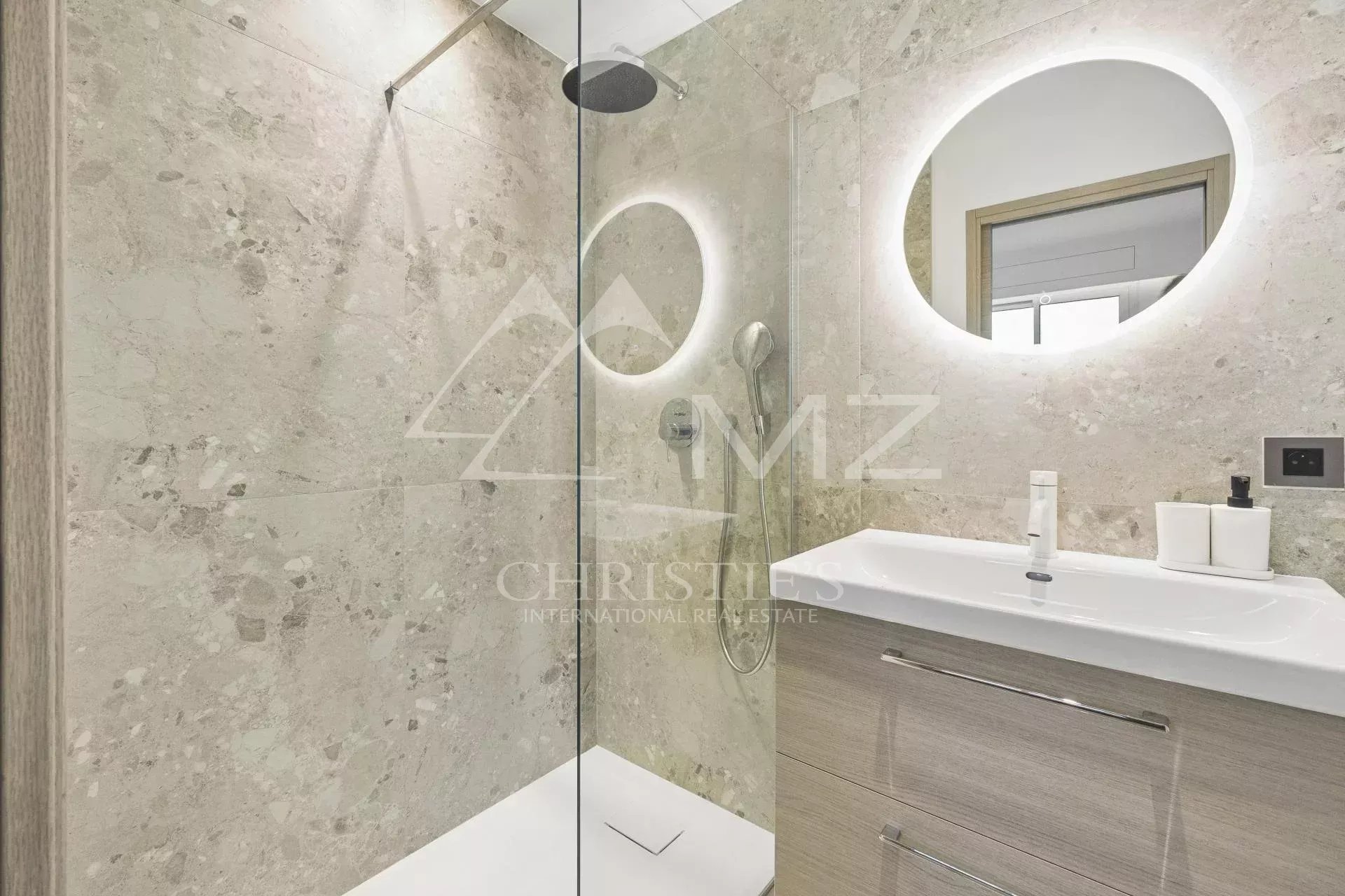Modern bathroom with glass shower and wooden vanity unit.