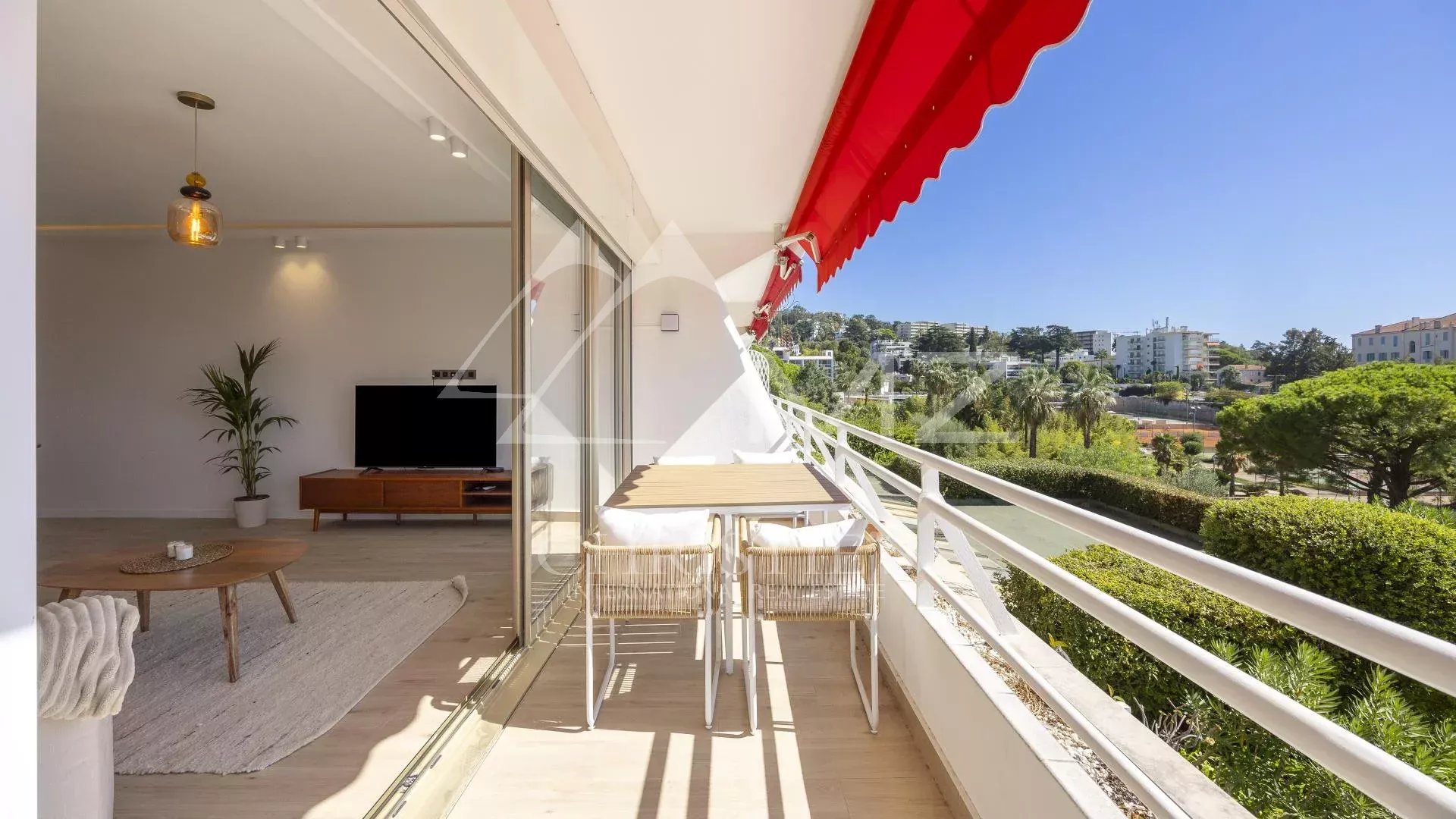 Terrace of a renovated apartment in Cannes with unobstructed views and a glimpse of the sea.