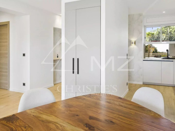 Interior of a renovated apartment in Cannes, with a bright living room and open kitchen.