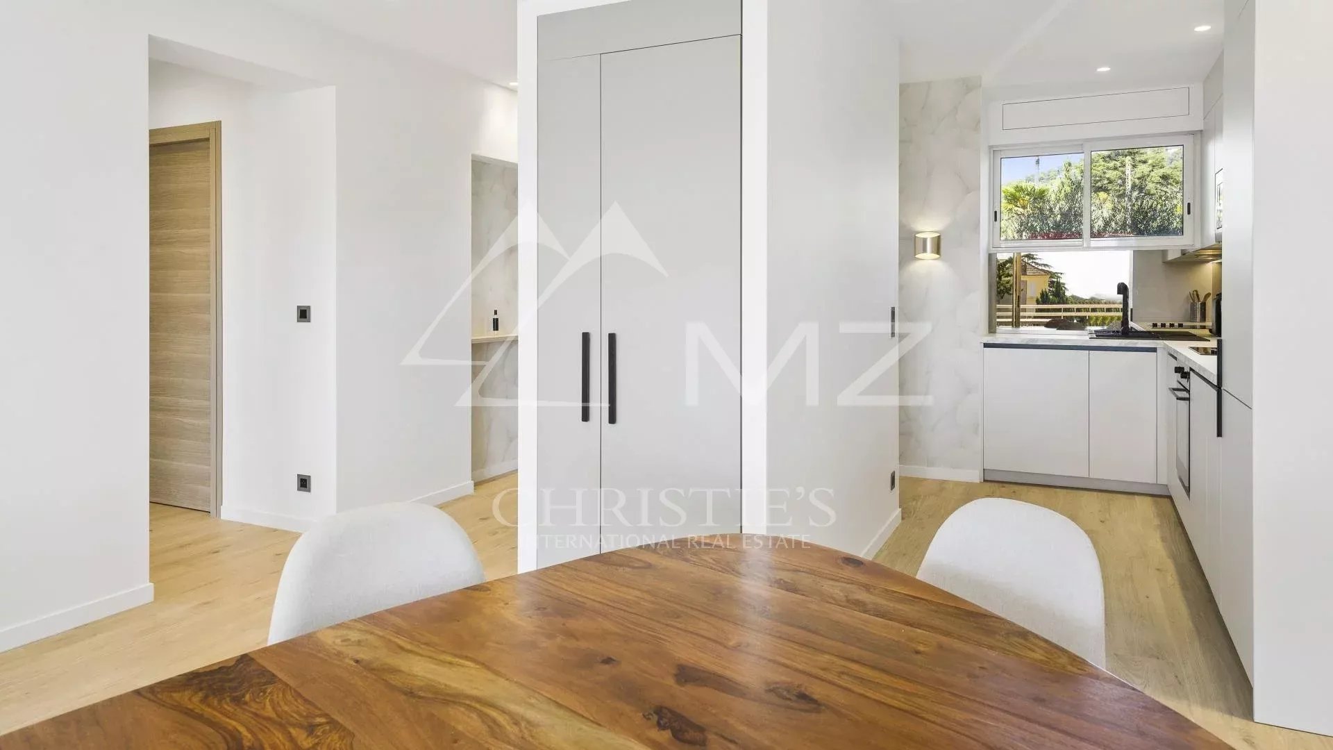 Interior of a renovated apartment in Cannes, with a bright living room and open kitchen.