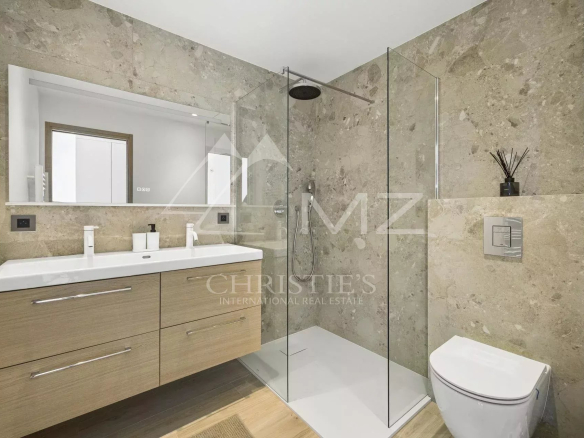 Modern bathroom with glass shower and wooden vanity.