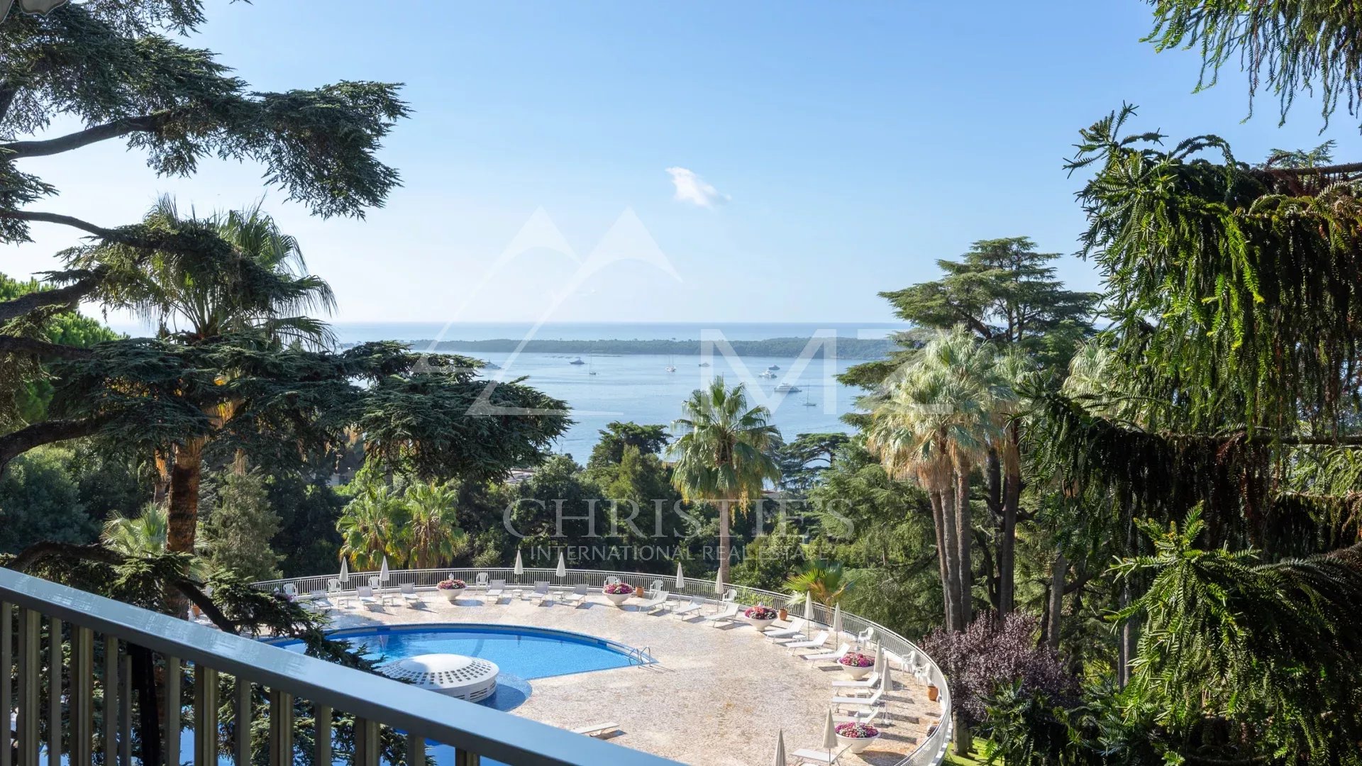 Sea view from an apartment in Cannes Unobstructed sea view from an apartment terrace in Cannes, with swimming pool and park below.