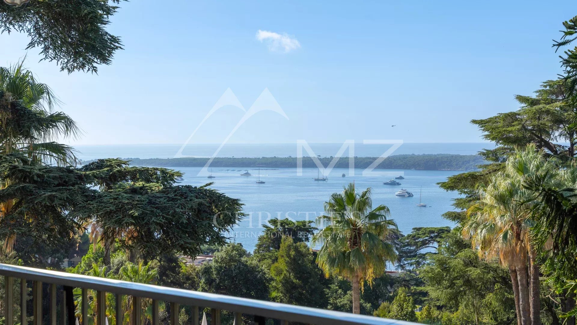 Sea view from an apartment in Cannes Unobstructed sea view from an apartment terrace in Cannes, with trees and boats in the distance.
