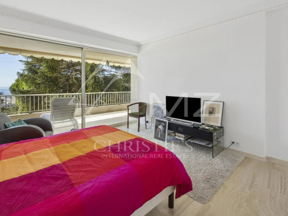 Chambre d'un appartement contemporain à Cannes avec vue sur la mer et accès à une terrasse.