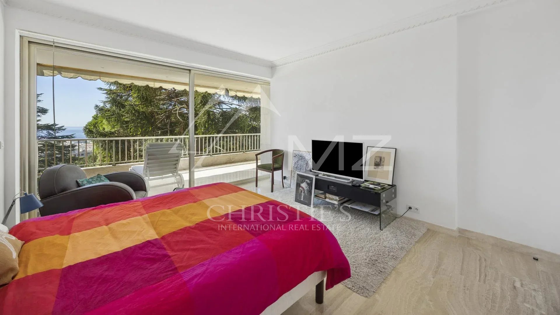 Chambre d'un appartement contemporain à Cannes avec vue sur la mer et accès à une terrasse.