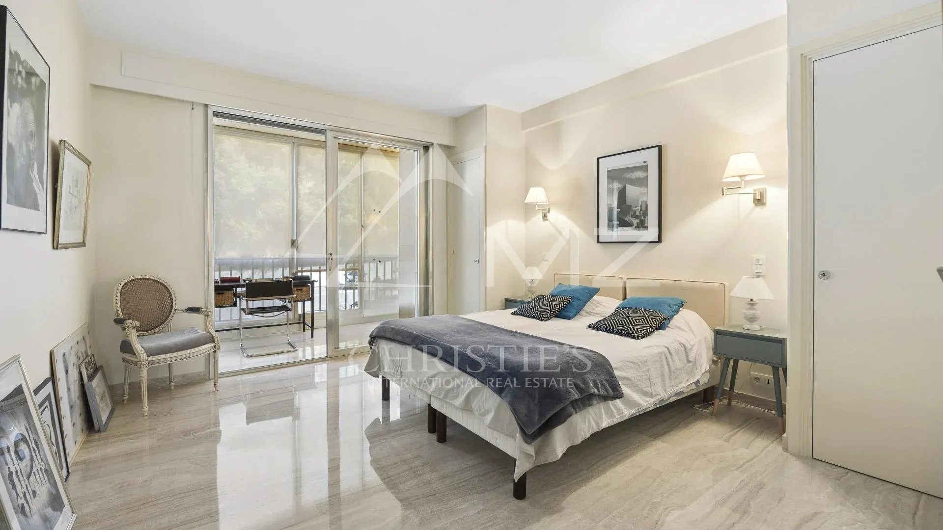 Chambre d'un appartement contemporain à Cannes avec vue sur la mer et accès à une terrasse.