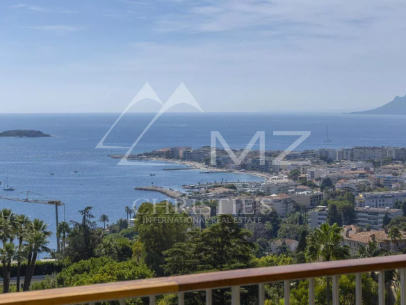 Vue panoramique sur la mer et la ville de Cannes depuis un balcon.