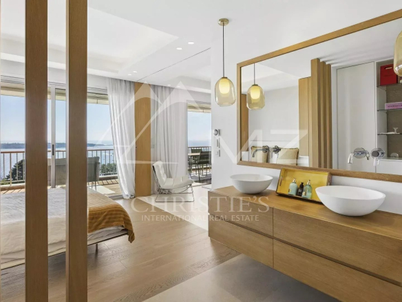 Salle de bain moderne avec deux lavabos et vue sur la mer à Cannes.
