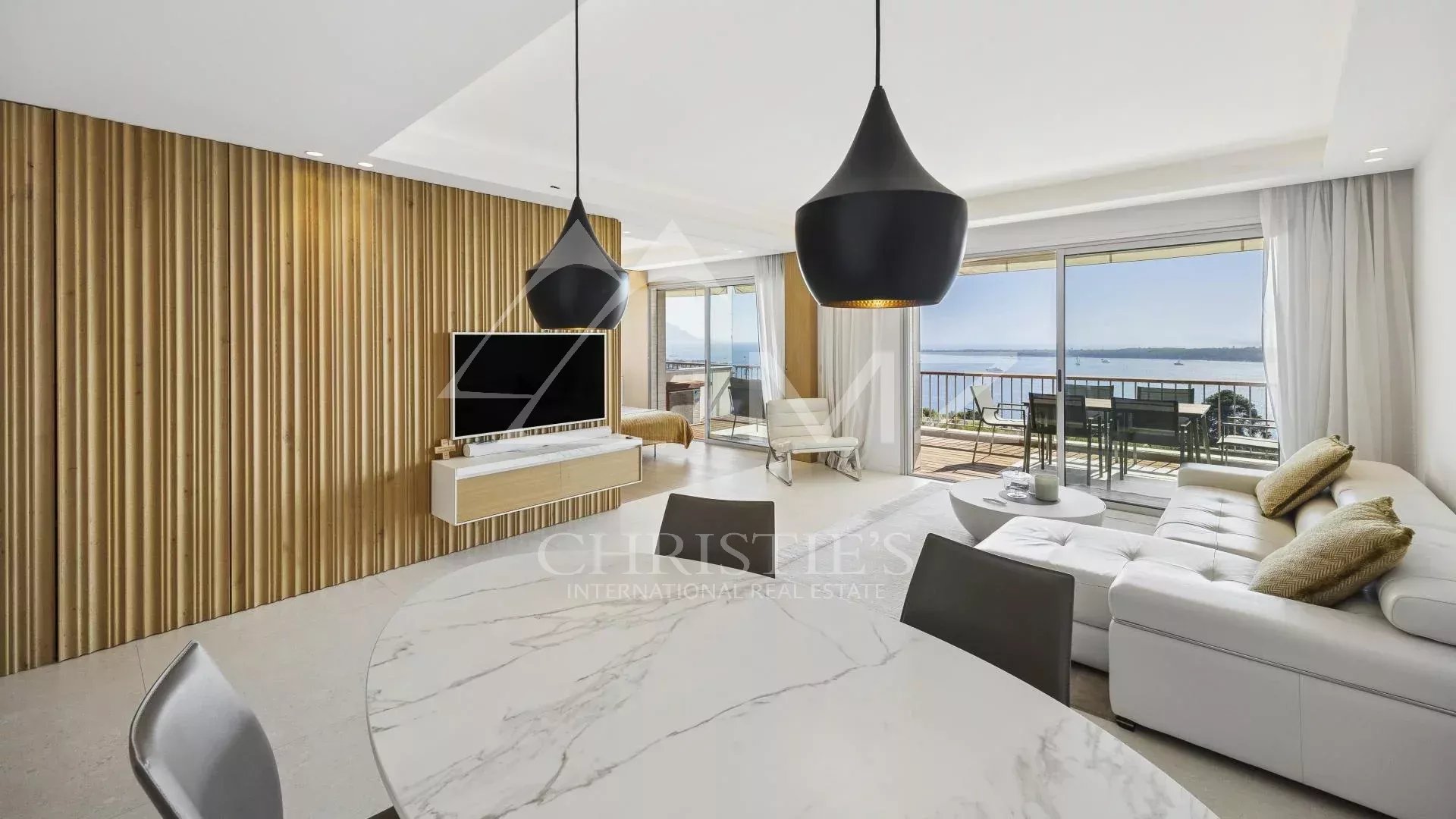 Appartement contemporain à Cannes Intérieur d'un appartement contemporain avec vue mer à Cannes, salon lumineux et mobilier moderne.